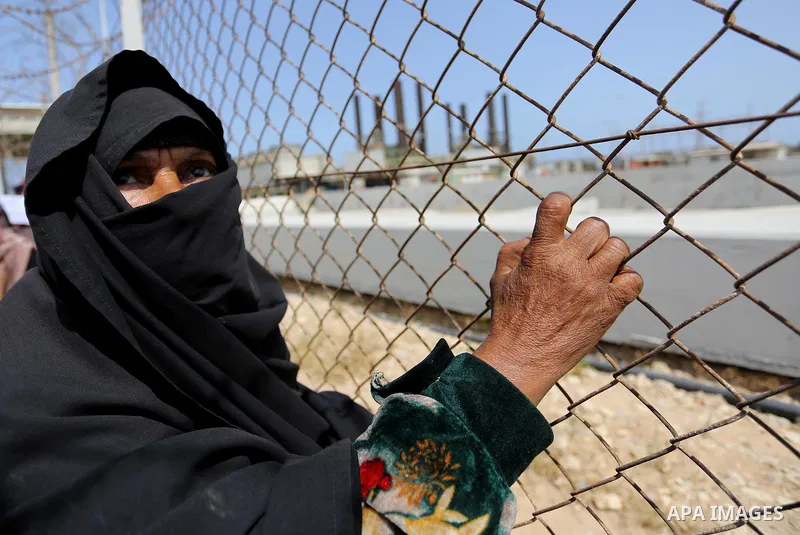 A Palestinian woman stands by a fence during a protest calling for an end to the power crisis, outside the power plant in the central Gaza Strip April 23, 2017. Photo by Ashraf Amra