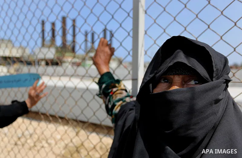 A Palestinian woman stands by a fence during a protest calling for an end to the power crisis, outside the power plant in the central Gaza Strip April 23, 2017. Photo by Ashraf Amra
