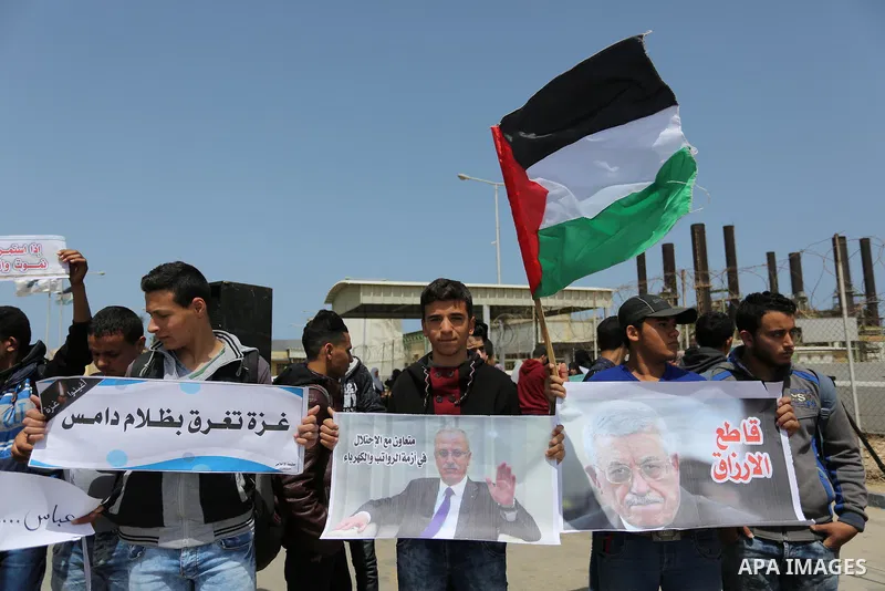Palestinian school boys hold banners during a protest calling for an end to the power crisis, outside the power plant in the central Gaza Strip April 23, 2017. Photo by Ashraf Amra