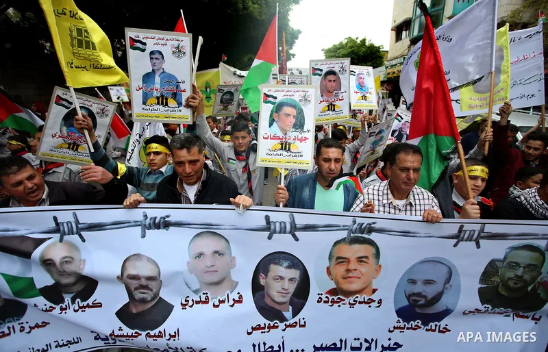 Palestinian protesters hold banners during a demonstration in solidarity with Palestinian prisoners on hunger strike in Israeli jails, in the West Bank of Nablus on April 23, 2017. Some 1,500 Palestinian prisoners have j...
