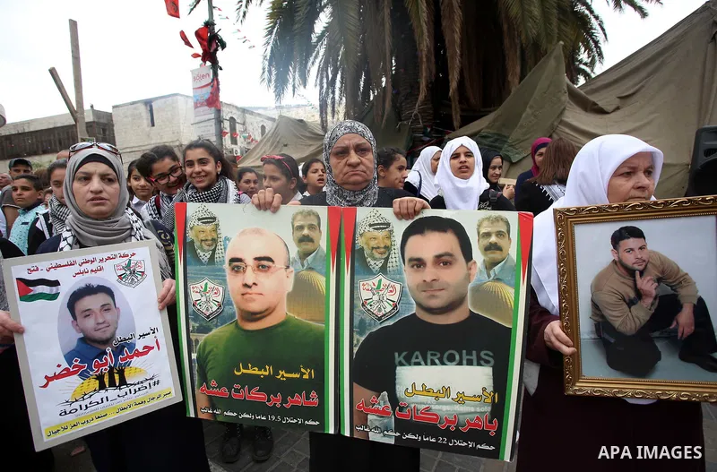 Palestinian protesters hold banners during a demonstration in solidarity with Palestinian prisoners on hunger strike in Israeli jails, in the West Bank of Nablus on April 23, 2017. Some 1,500 Palestinian prisoners have j...