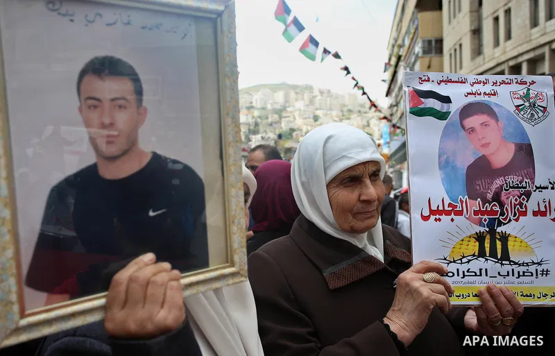 Palestinian protesters hold banners during a demonstration in solidarity with Palestinian prisoners on hunger strike in Israeli jails, in the West Bank of Nablus on April 23, 2017. Some 1,500 Palestinian prisoners have j...