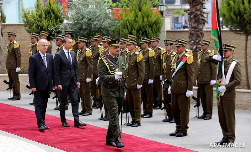 Palestinian Prime Minister Rami Hamdallah and Austria's Chancellor Christian Kern review the honor guard during a welcome ceremony in the West Bank city of Ramallah, on April 23, 2017. Photo by Prime Minister Office