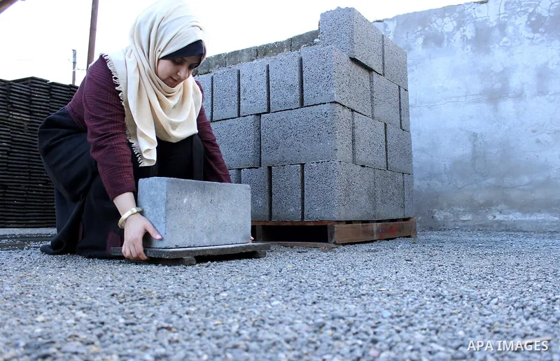 Majd Al Mashharawi, a Palestinian woman produce cement blocks and stones from the remains of houses destroyed by Israeli shelling during the 50-day Israeli war in the summer of 2014 in Gaza city on Feb. 11, 2017. Al Mash...