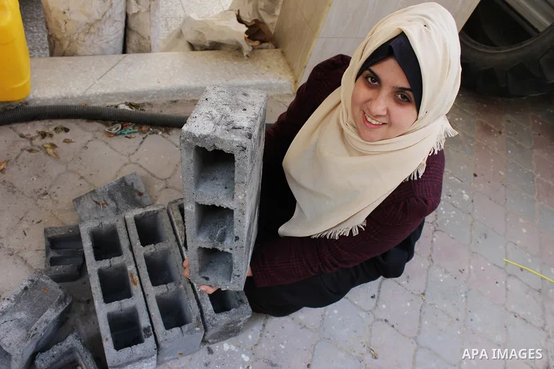 Majd Al Mashharawi, a Palestinian woman produce cement blocks and stones from the remains of houses destroyed by Israeli shelling during the 50-day Israeli war in the summer of 2014 in Gaza city on Feb. 11, 2017. Al Mash...