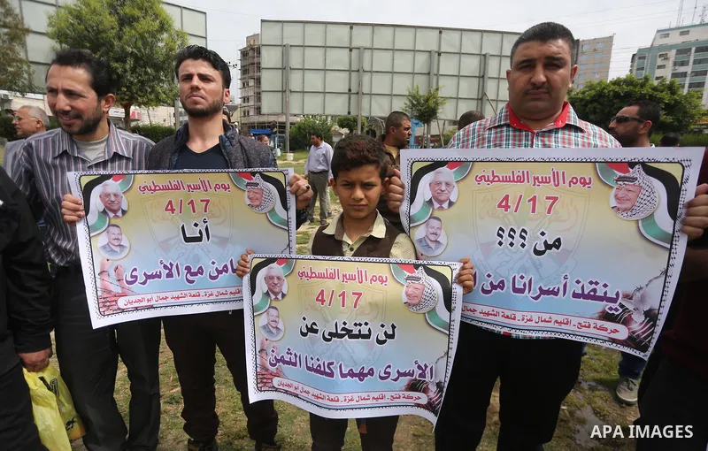 Palestinian protesters hold banners during a protest in solidarity with Palestinian prisoners on hunger strike in Israeli jails, in Gaza city on April 24, 2017. Some 1,500 Palestinian prisoners have joined the hunger str...