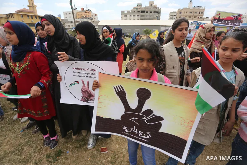 Palestinian protesters hold banners during a protest in solidarity with Palestinian prisoners on hunger strike in Israeli jails, in Gaza city on April 24, 2017. Some 1,500 Palestinian prisoners have joined the hunger str...