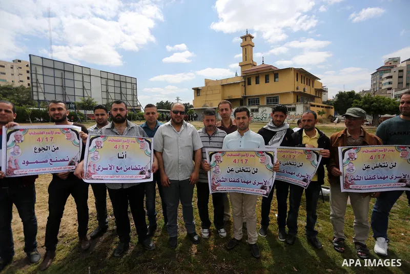 Palestinian protesters hold banners during a protest in solidarity with Palestinian prisoners on hunger strike in Israeli jails, in Gaza city on April 24, 2017. Some 1,500 Palestinian prisoners have joined the hunger str...