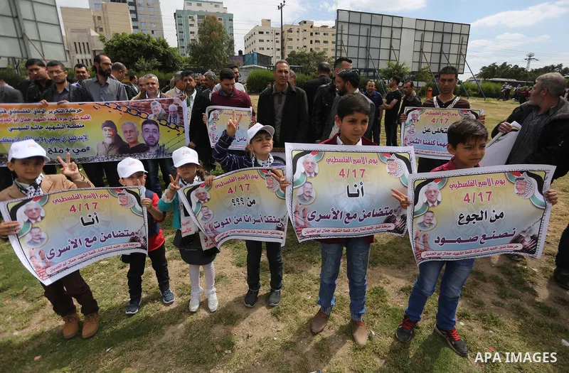 Palestinian protesters hold banners during a protest in solidarity with Palestinian prisoners on hunger strike in Israeli jails, in Gaza city on April 24, 2017. Some 1,500 Palestinian prisoners have joined the hunger str...