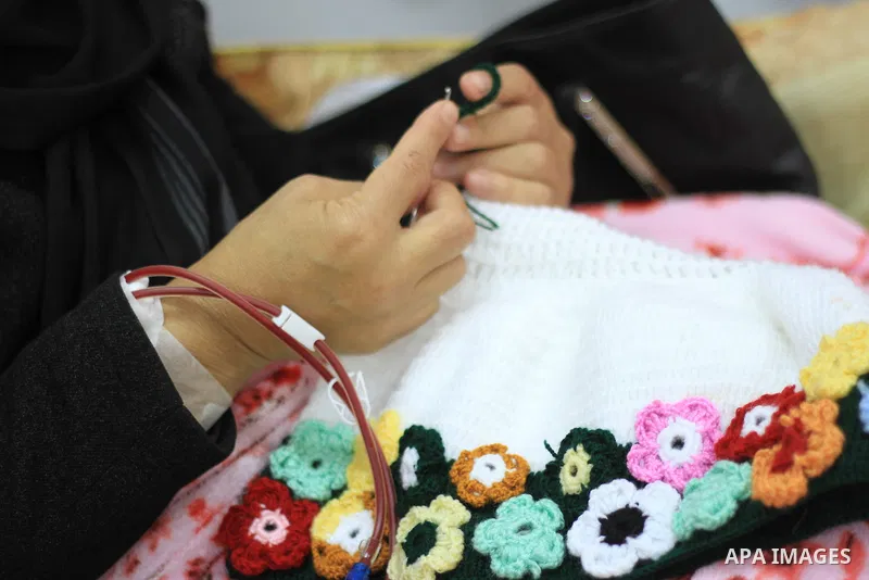 Seham al-Helow, 40, a Palestinian patient woman gets her kidneys washed at the dialysis department in the Al-Shifa hospital as she makes crochet dresses in Gaza City on Feb. 14, 2017. al-Helow is one of the women who mas...