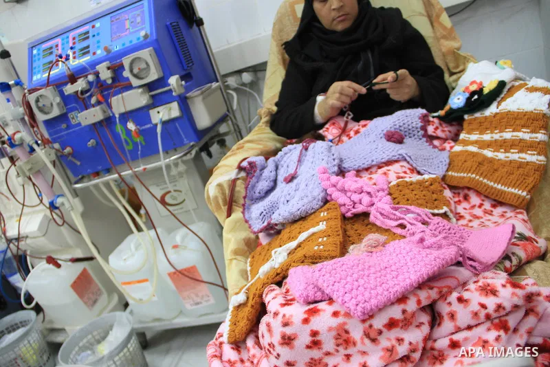 Seham al-Helow, 40, a Palestinian patient woman gets her kidneys washed at the dialysis department in the Al-Shifa hospital as she makes crochet dresses in Gaza City on Feb. 14, 2017. al-Helow is one of the women who mas...