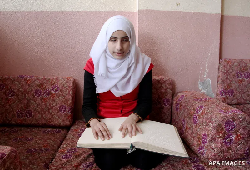 Asmaa Abu Hilal,18, a Palestinian blind student reads a copy of the holy Koran in braille at her family house in Rafah in the southern Gaza strip on Feb. 14, 2017. Abu Hilal superior at her study although there are no pr...