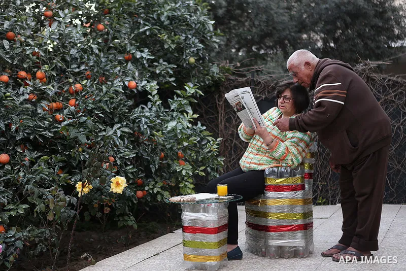 Evet Azzam, a Palestinian Christians woman, 53, reads a newspaper with her husbund at their house, in Gaza city on Feb. 10, 2017. Azzam uses an useless home materials to produce clocks, Nylon bags, chairs and tables by a...