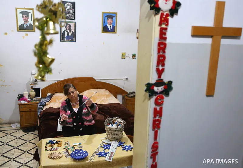 Evet Azzam, a Palestinian Christians woman, 53, makes a handmade clock from recycled newspapers at her house, in Gaza city on Feb. 10, 2017. Azzam uses an useless home materials to produce clocks, Nylon bags, chairs and...