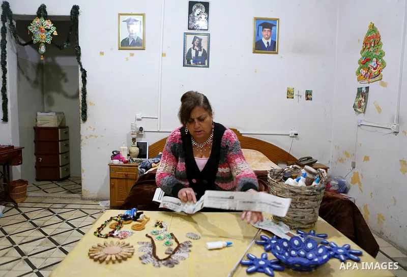 Evet Azzam, a Palestinian Christians woman, 53, makes a handmade clock from recycled newspapers at her house, in Gaza city on Feb. 10, 2017. Azzam uses an useless home materials to produce clocks, Nylon bags, chairs and...