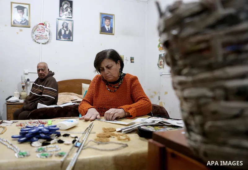 Evet Azzam, a Palestinian Christians woman, 53, makes a handmade clock from recycled newspapers at her house, in Gaza city on Feb. 10, 2017. Azzam uses an useless home materials to produce clocks, Nylon bags, chairs and...