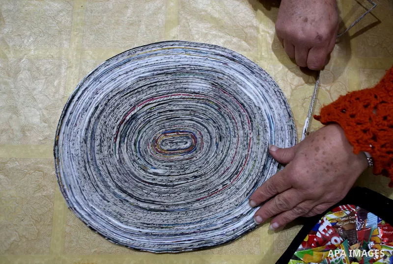Evet Azzam, a Palestinian Christians woman, 53, makes a handmade clock from recycled newspapers at her house, in Gaza city on Feb. 10, 2017. Azzam uses an useless home materials to produce clocks, Nylon bags, chairs and...
