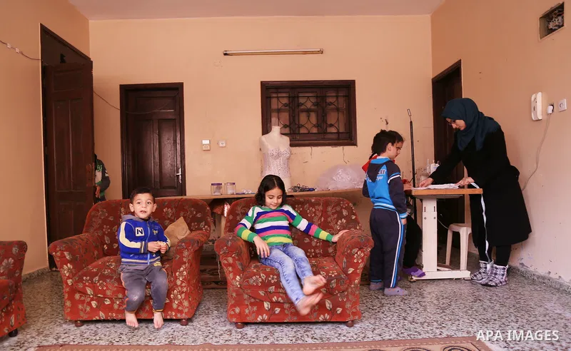 Manar Tafesh, 30, a Palestinian fashion designer works on knitting wedding dresses at her house with her husband to help him after he lost his work as tailor in the Palestinian territory occupied, in Gaza city on Feb. 14...