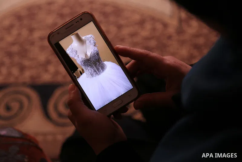 Manar Tafesh, 30, a Palestinian fashion designer works on knitting wedding dresses at her house with her husband to help him after he lost his work as tailor in the Palestinian territory occupied, in Gaza city on Feb. 14...
