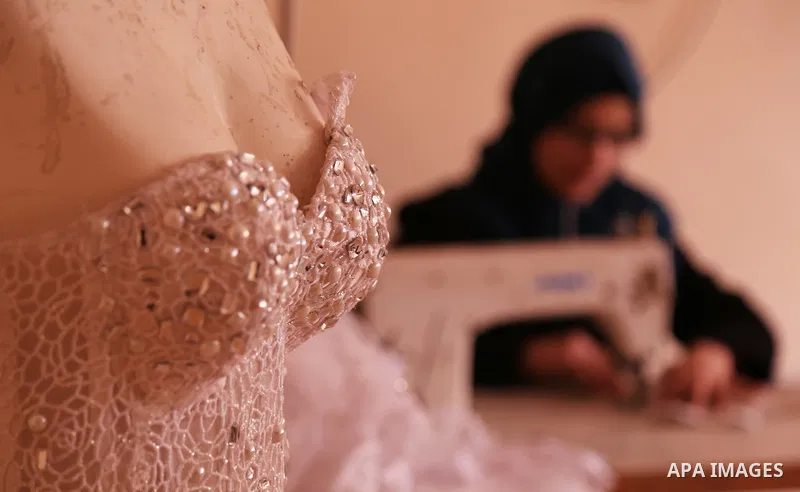 Manar Tafesh, 30, a Palestinian fashion designer works on knitting wedding dresses at her house with her husband to help him after he lost his work as tailor in the Palestinian territory occupied, in Gaza city on Feb. 14...