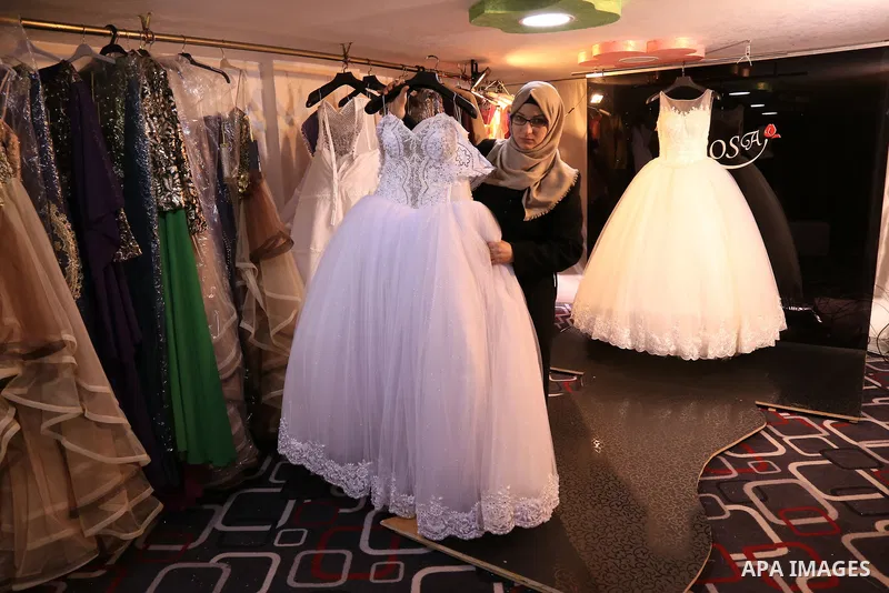 Manar Tafesh, 30, a Palestinian fashion designer works on knitting wedding dresses at her house with her husband to help him after he lost his work as tailor in the Palestinian territory occupied, in Gaza city on Feb. 14...