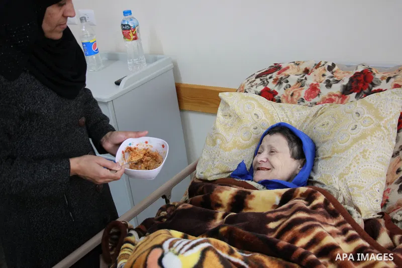 A Palestinian female worker helps an elderly Palestinian woman to eat her lunch meal at El Wafa elderly nursing home, in Gaza city on Feb. 12, 2017. El Wafa elderly nursing home was established in 1980 as one of programs...