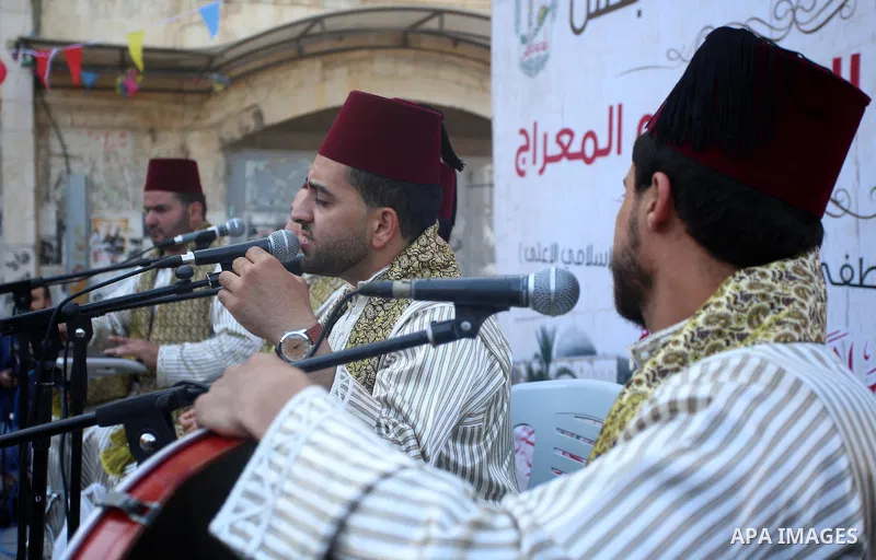 Palestinians Muslim Sufis play musical instruments as they parade through the streets during a ceremony commemorating the Islamic holiday of Isra Mi'raj in the West Bank city of Nablus on April 24, 2017. The holiday mark...