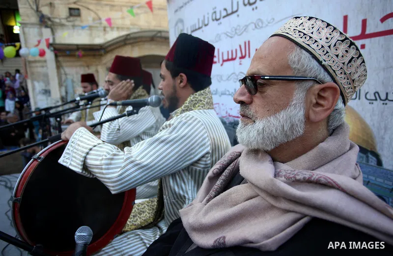 Palestinians Muslim Sufis play musical instruments as they parade through the streets during a ceremony commemorating the Islamic holiday of Isra Mi'raj in the West Bank city of Nablus on April 24, 2017. The holiday mark...