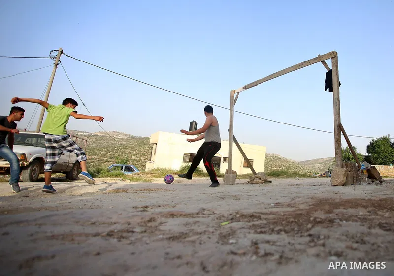 A picture taken on April 22, 2017 shows Palestinian boys play football, in the West Bank city of Nablus. Photo by Ayman Ameen