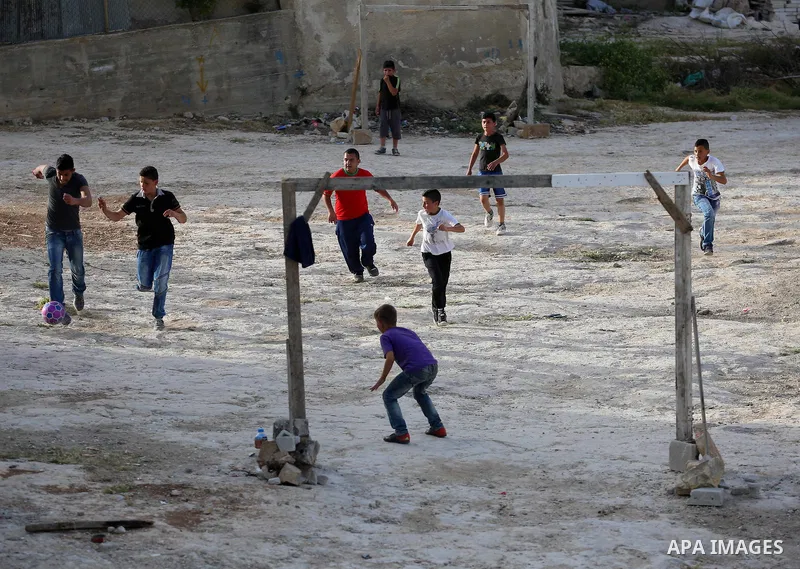 A picture taken on April 22, 2017 shows Palestinian boys play football, in the West Bank city of Nablus. Photo by Ayman Ameen