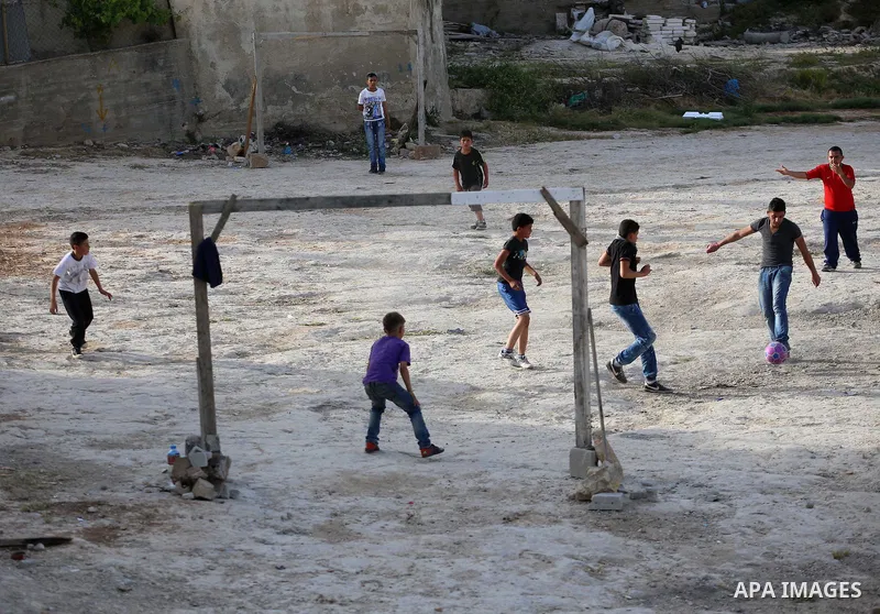A picture taken on April 22, 2017 shows Palestinian boys play football, in the West Bank city of Nablus. Photo by Ayman Ameen