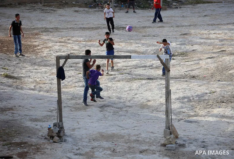 A picture taken on April 22, 2017 shows Palestinian boys play football, in the West Bank city of Nablus. Photo by Ayman Ameen