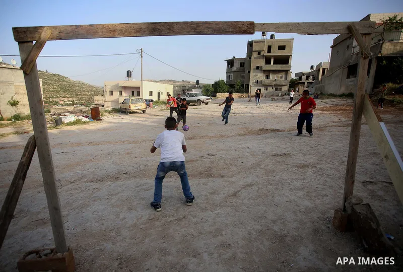 A picture taken on April 22, 2017 shows Palestinian boys play football, in the West Bank city of Nablus. Photo by Ayman Ameen
