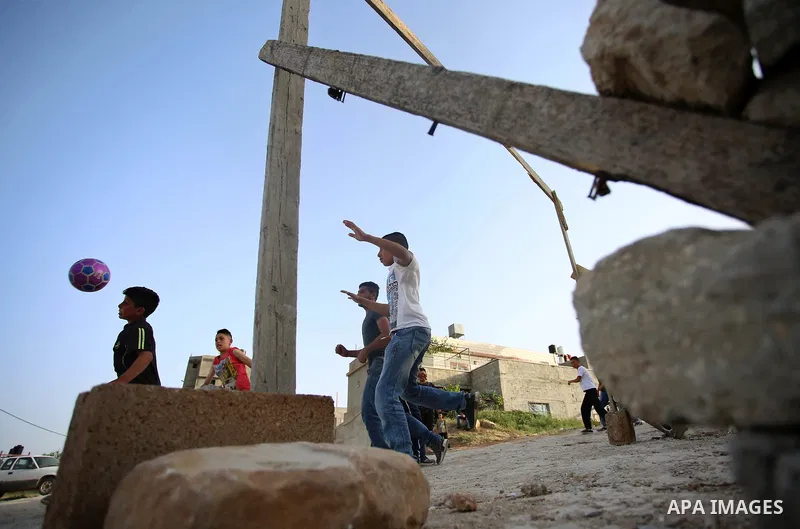 A picture taken on April 22, 2017 shows Palestinian boys play football, in the West Bank city of Nablus. Photo by Ayman Ameen