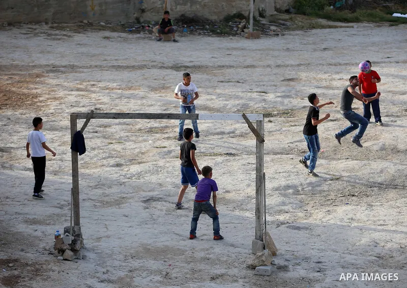 A picture taken on April 22, 2017 shows Palestinian boys play football, in the West Bank city of Nablus. Photo by Ayman Ameen