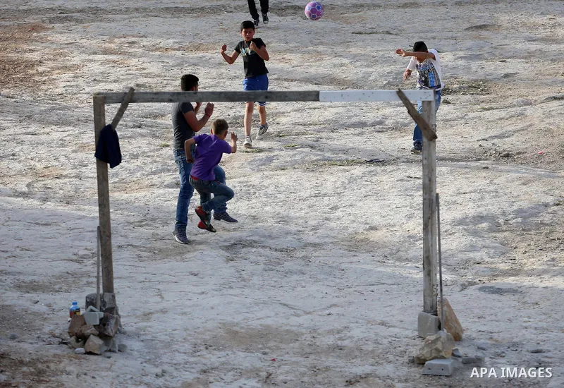 A picture taken on April 22, 2017 shows Palestinian boys play football, in the West Bank city of Nablus. Photo by Ayman Ameen