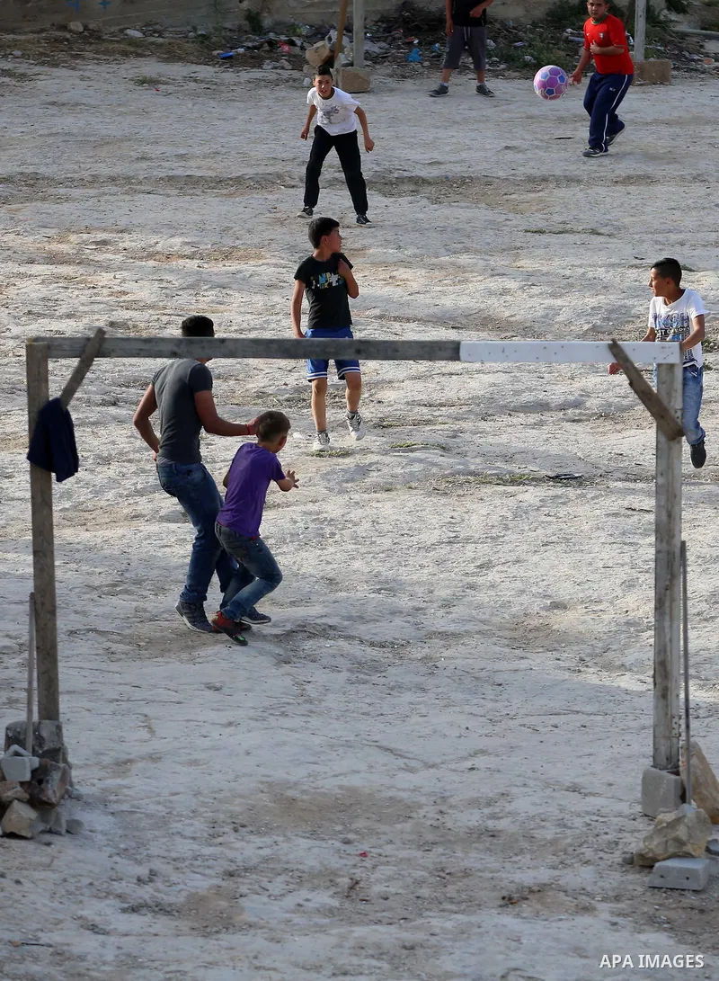 A picture taken on April 22, 2017 shows Palestinian boys play football, in the West Bank city of Nablus. Photo by Ayman Ameen