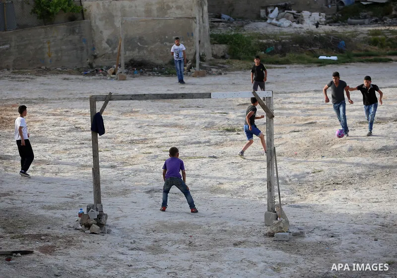 A picture taken on April 22, 2017 shows Palestinian boys play football, in the West Bank city of Nablus. Photo by Ayman Ameen