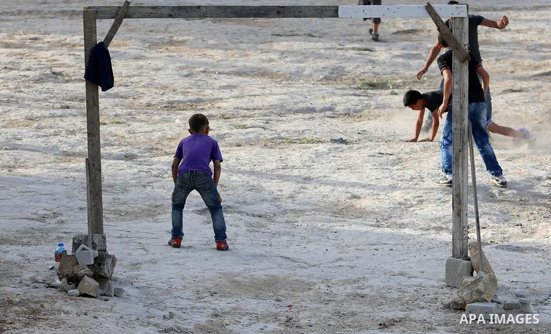 A picture taken on April 22, 2017 shows Palestinian boys play football, in the West Bank city of Nablus. Photo by Ayman Ameen