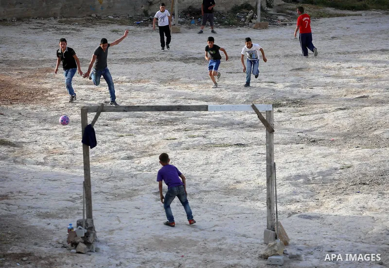 A picture taken on April 22, 2017 shows Palestinian boys play football, in the West Bank city of Nablus. Photo by Ayman Ameen