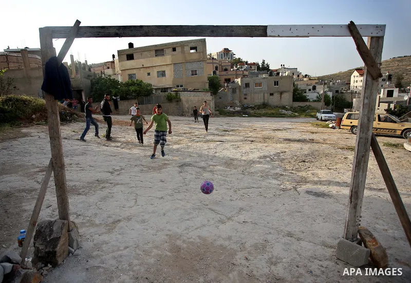 A picture taken on April 22, 2017 shows Palestinian boys play football, in the West Bank city of Nablus. Photo by Ayman Ameen