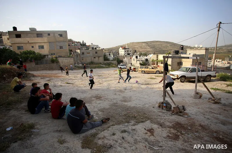 A picture taken on April 22, 2017 shows Palestinian boys play football, in the West Bank city of Nablus. Photo by Ayman Ameen