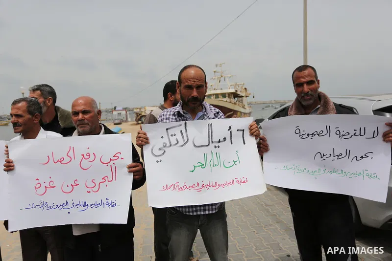 Palestinian fishermen hold banners during a protest demanding end an Israeli blockade of the Gaza Strip, in Gaza city on April 26, 2017. Photo by Ashraf Amra