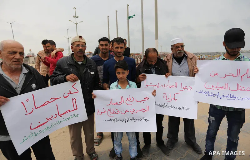 Palestinian fishermen hold banners during a protest demanding end an Israeli blockade of the Gaza Strip, in Gaza city on April 26, 2017. Photo by Ashraf Amra