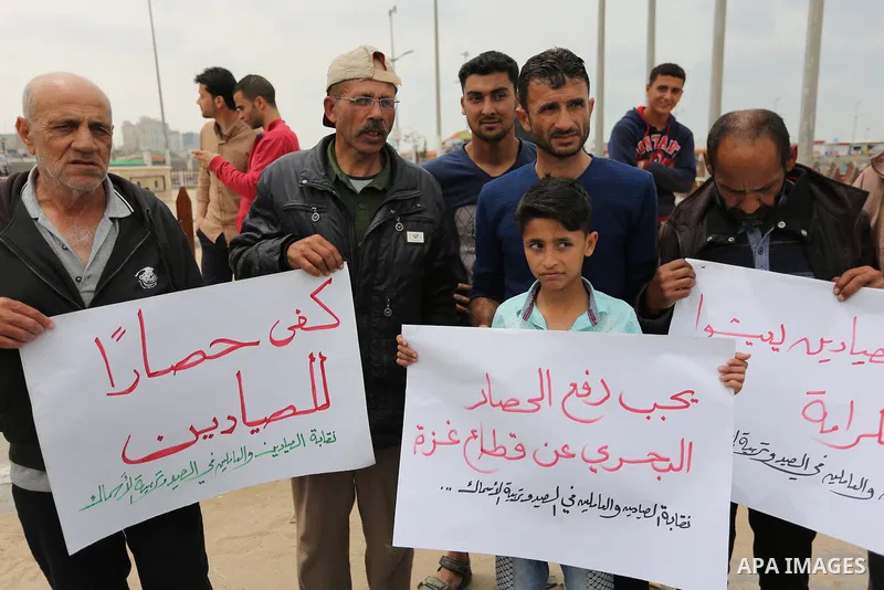 Palestinian fishermen hold banners during a protest demanding end an Israeli blockade of the Gaza Strip, in Gaza city on April 26, 2017. Photo by Ashraf Amra