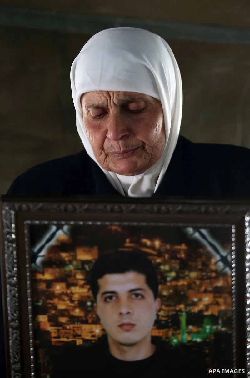 A Palestinian woman holds a picture of her son who held in Israeli jails at a protest tent in support of Palestinian prisoners on hunger strike in Israeli jails, in the West Bank city of Nablus on April 26, 2017. Photo b...