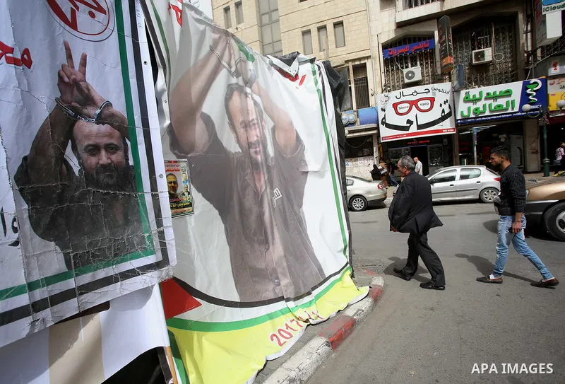 Palestinians walk past a a protest tent in support of Palestinian prisoners on hunger strike in Israeli jails, in the West Bank city of Nablus on April 26, 2017. Photo by Ayman Ameen