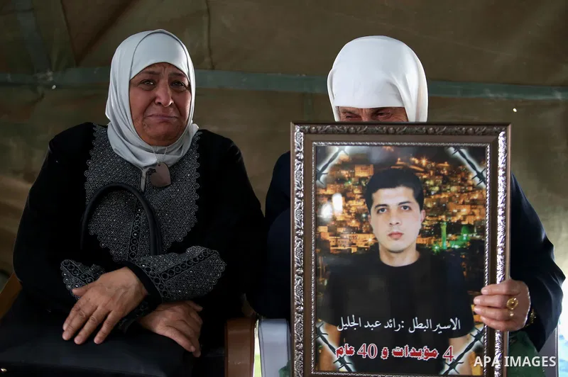 A Palestinian woman holds a picture of her son who held in Israeli jails at a protest tent in support of Palestinian prisoners on hunger strike in Israeli jails, in the West Bank city of Nablus on April 26, 2017. Photo b...