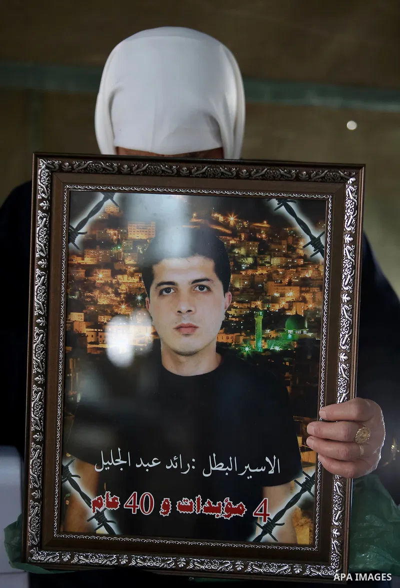 A Palestinian woman holds a picture of her son who held in Israeli jails at a protest tent in support of Palestinian prisoners on hunger strike in Israeli jails, in the West Bank city of Nablus on April 26, 2017. Photo b...