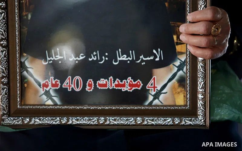 A Palestinian woman holds a picture of her son who held in Israeli jails at a protest tent in support of Palestinian prisoners on hunger strike in Israeli jails, in the West Bank city of Nablus on April 26, 2017. Photo b...